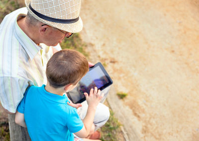 Rear view of man using mobile phone