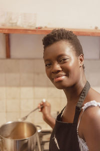 Portrait of young woman drinking water at home