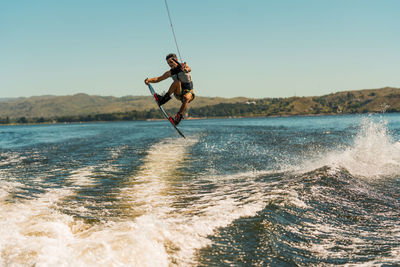 Full length of man wakeboarding in sea