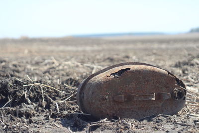 Close-up of rusty metal on field against clear sky