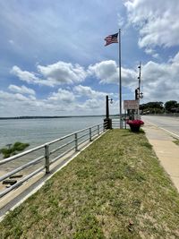 Scenic view of street by sea against sky