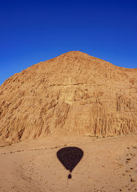 View of desert against clear blue sky