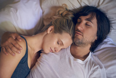 Man and woman sleeping on bed at home