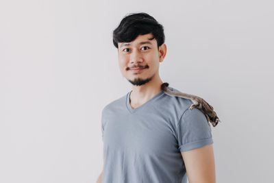 Portrait of young man standing against white background