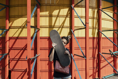 Portrait of woman holding skateboard