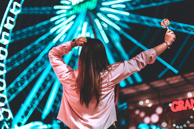 Rear view of woman dancing at music concert