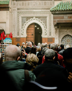 Rear view of people at temple against building