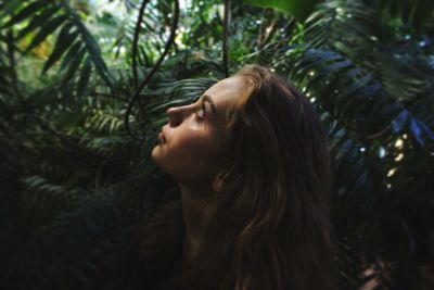 Close-up of young woman against trees