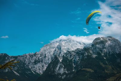 Person paragliding against mountain