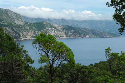 Scenic view of sea and mountains against sky