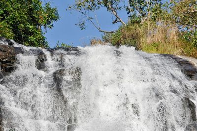 Low angle view of waterfall against sky