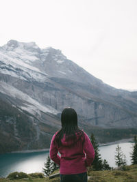 Rear view of woman looking at mountains against sky