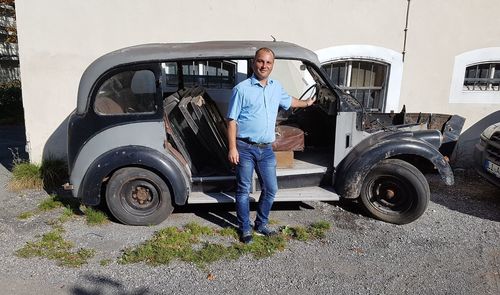 Portrait of man standing by car