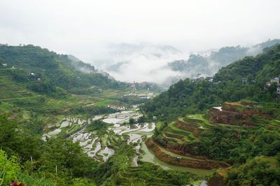 High angle view of agricultural field and mountains against sky