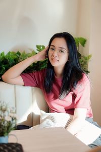 Portrait of young woman sitting on table