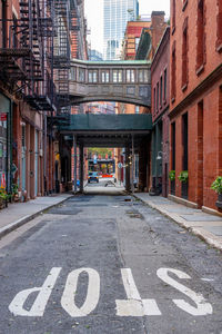 Road sign on street amidst buildings in city