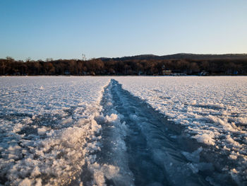 Scenic view of snow covered landscape against clear blue sky