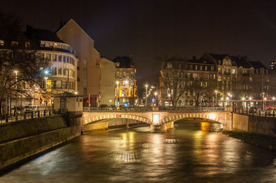 Bridge over river in city at night