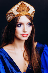 Close-up of beautiful woman in traditional clothing against black background