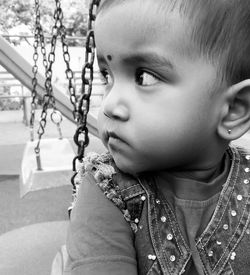 Close-up of boy on swing in park