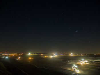 Illuminated city against sky at night