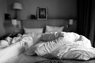 Low section of man relaxing on bed at home