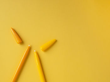 High angle view of pencils against yellow background