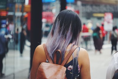 Rear view of woman standing on street in city