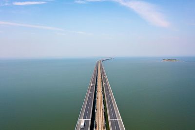 Scenic view of highway amidst sea against sky