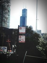 Road sign in city against clear sky