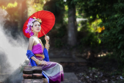 Rear view of woman holding umbrella