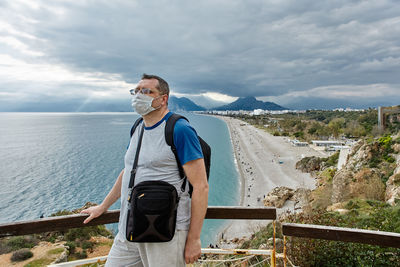 Man standing by sea against sky