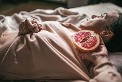 Midsection of woman lying on bed at home