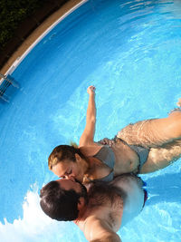 High angle view of couple embracing in swimming pool