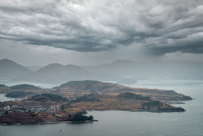 Scenic view of sea and mountains against sky