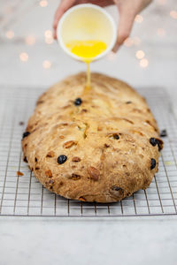 Cropped hand of woman pouring ingredient on bread