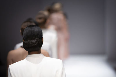 Rear view of man and woman standing against white background