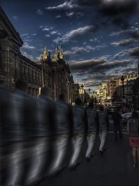 Buildings in city against cloudy sky