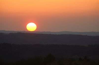Scenic view of silhouette landscape against orange sky