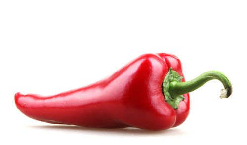 Close-up of red bell peppers against white background