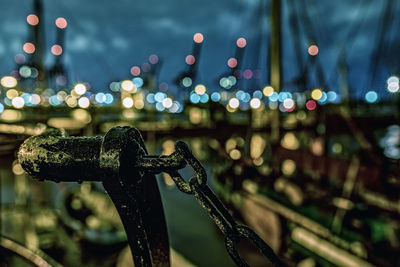 Close-up of metal in illuminated city at night