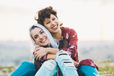 Portrait of smiling young woman against sky