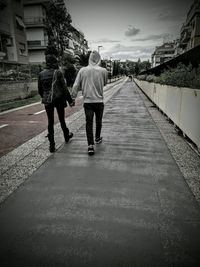 Rear view of men walking on road