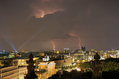 Illuminated buildings in city against sky at night