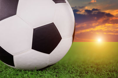 Close-up of soccer ball on playing field against sky 