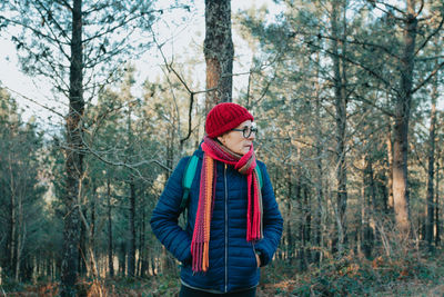 Rear view of woman standing in forest