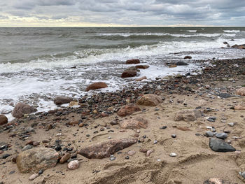 Rocks on beach against sky