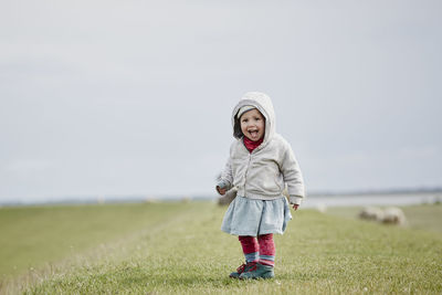 Germany, schleswig-holstein, eiderstedt, happy little girl standing on dyke