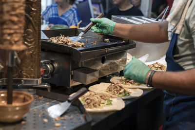 Midsection of man preparing food at market stall