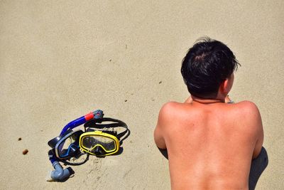 Rear view of shirtless man at beach